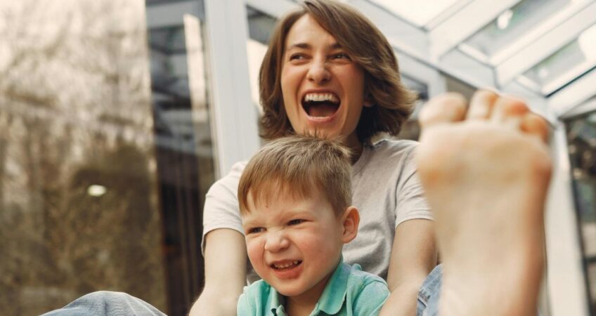 A mother and child giggle as they play.